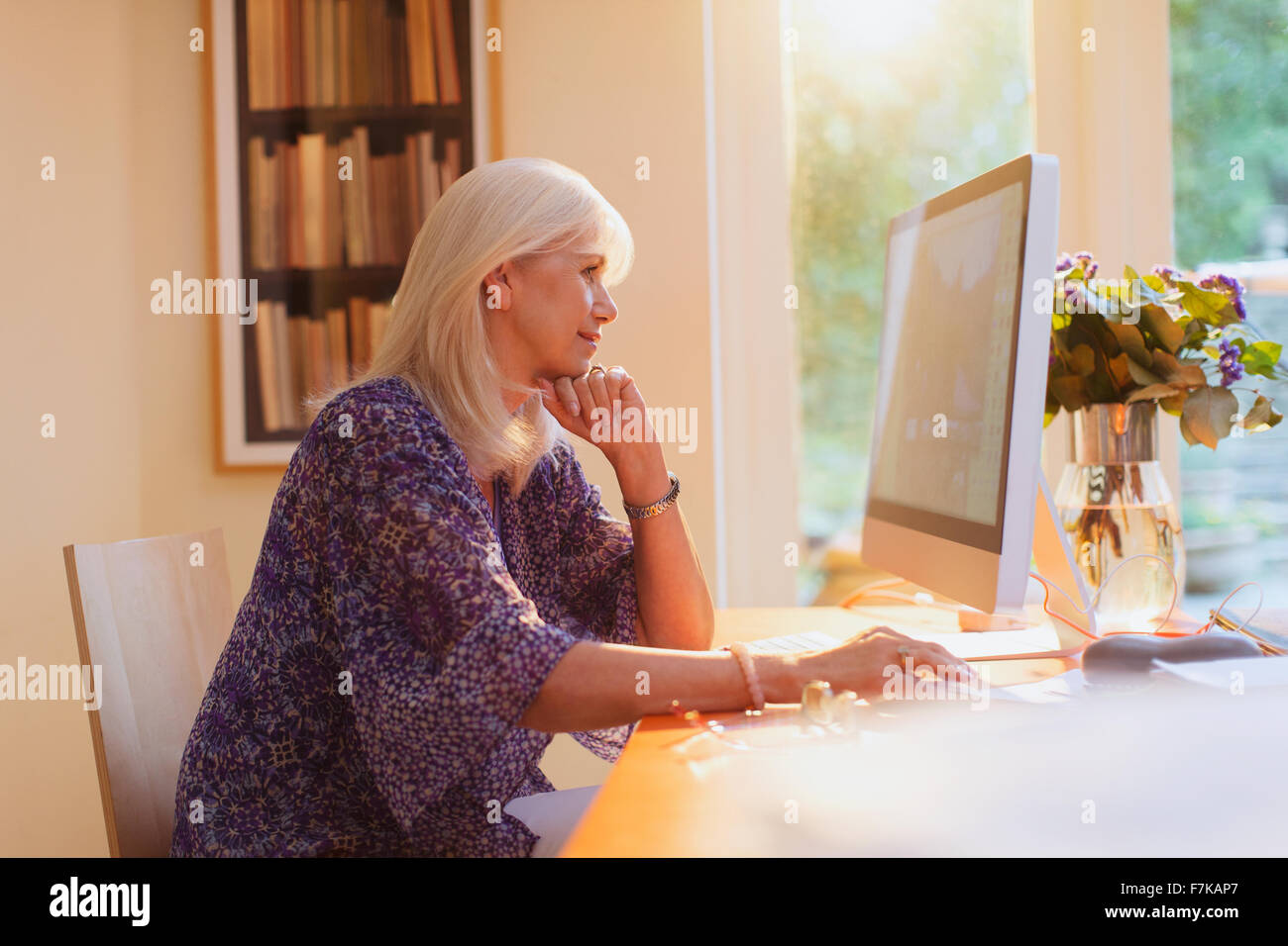 Senior woman working at computer in home office Stock Photo