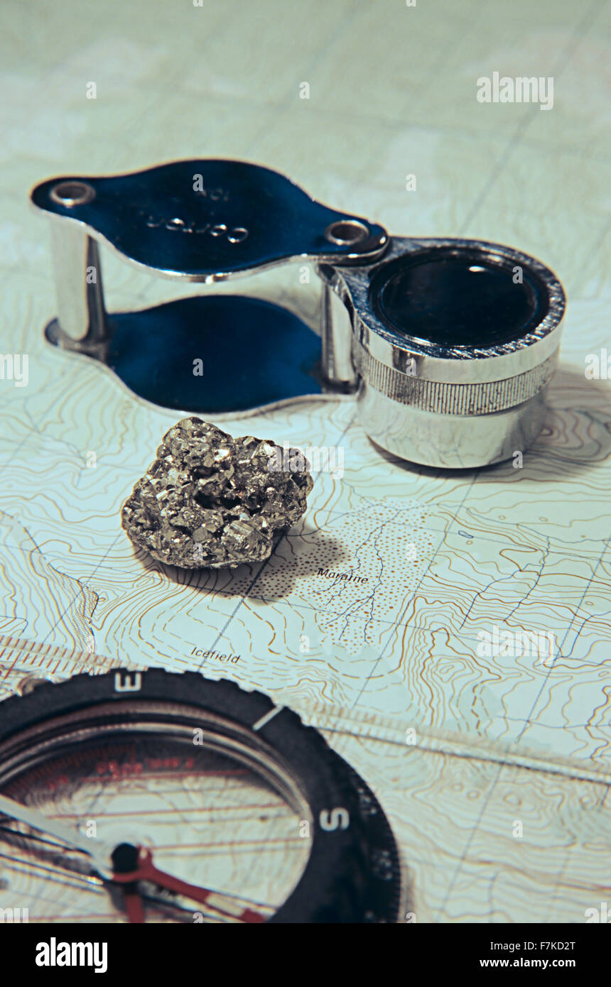 Mining exploration concept image with magnifier, mineral sample, and compass Stock Photo