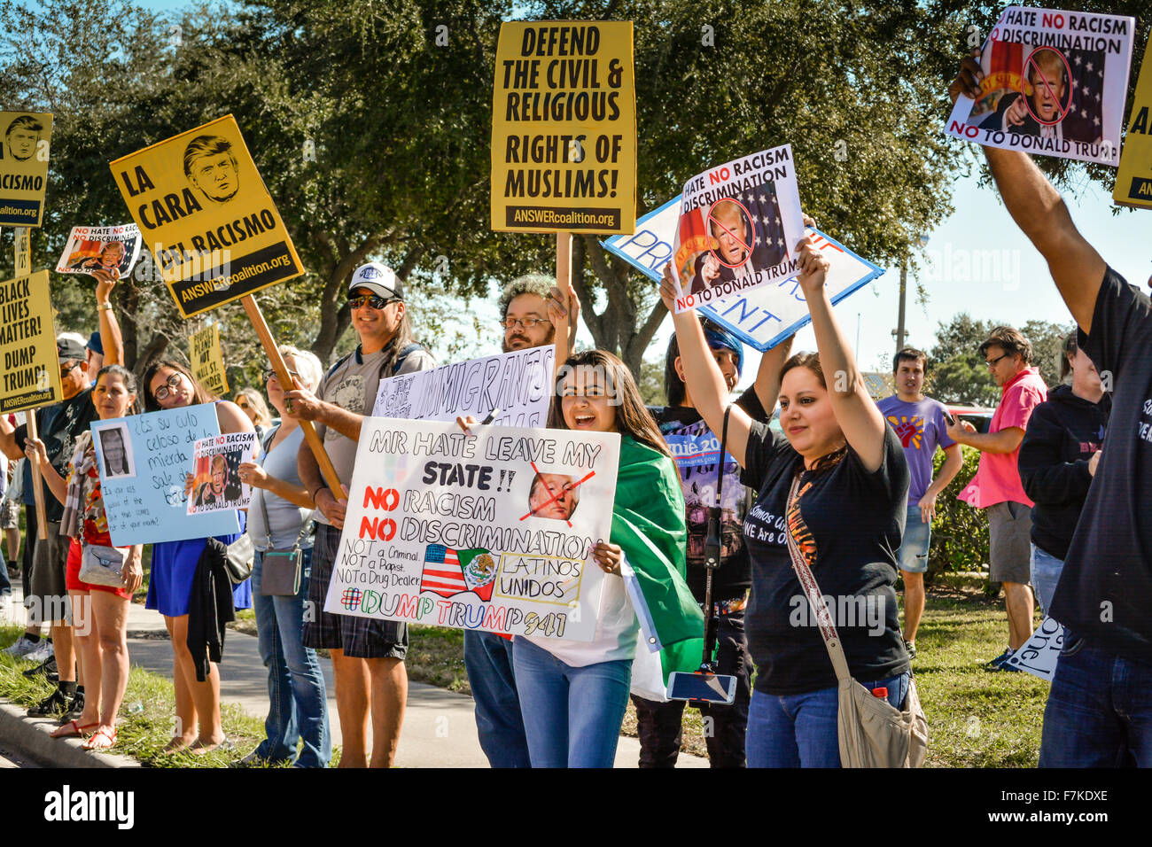 Protesters holding signs denouncing Donald Trump at a political rally for Trump in Sarasota, FL