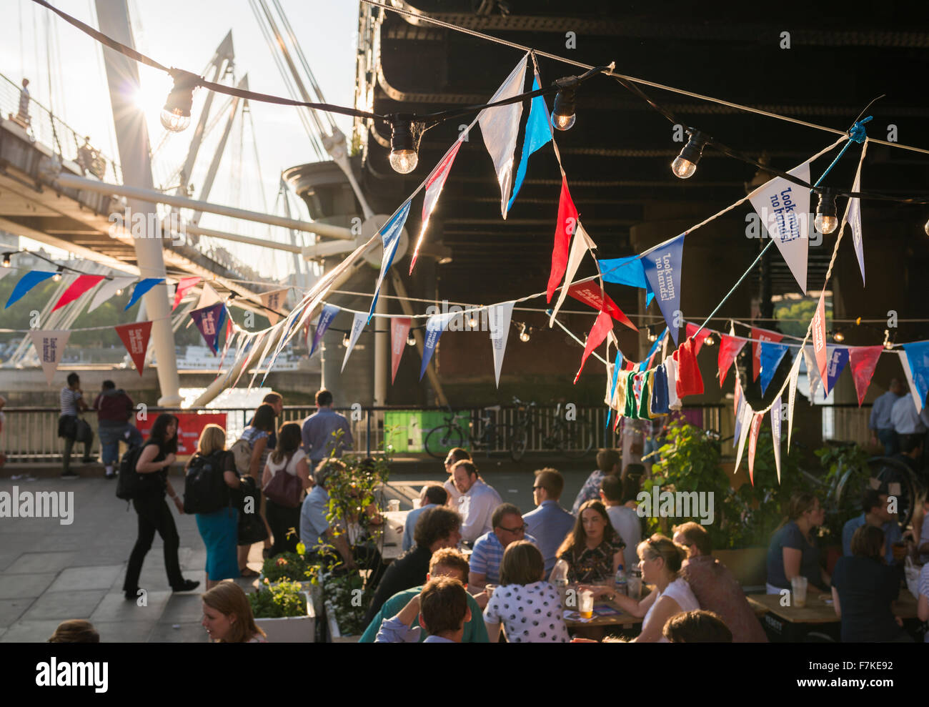 People enjoying an evening drink near the Golden Jubilee Bridge, South Bank, London, England, UK Stock Photo