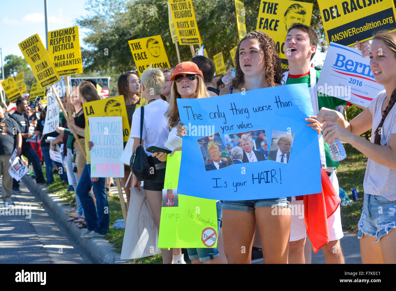 Protesters holding signs denouncing Donald Trump at a political rally for Trump in Sarasota, FL, USA Stock Photo