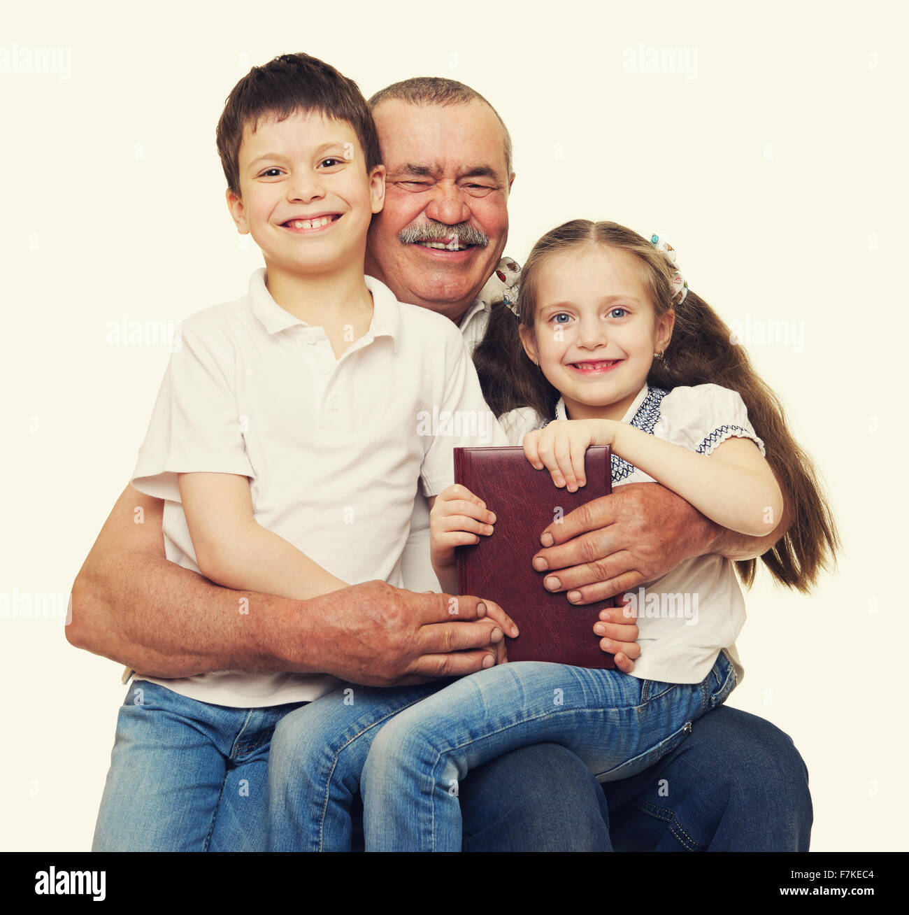 Grandfather and grandchildren read book on white Stock Photo