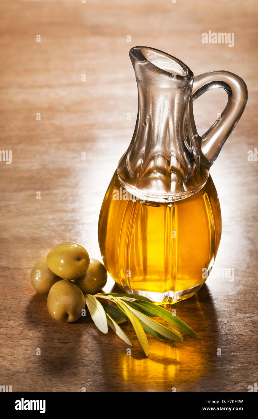 Olive oil and olive branch on the wooden table Stock Photo - Alamy