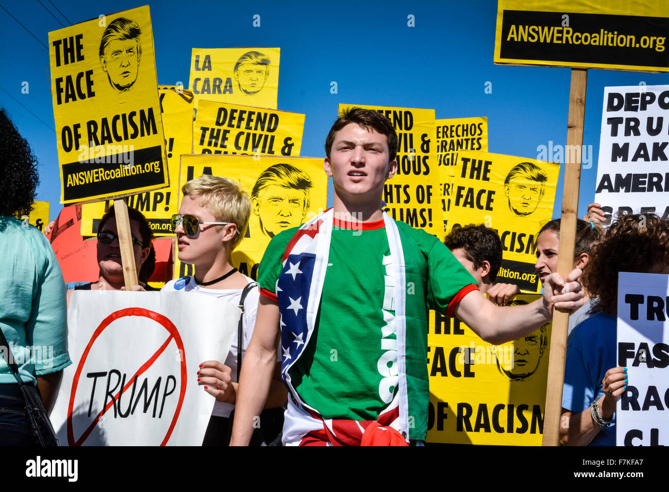 Protesters holding signs denouncing Donald Trump at a political rally