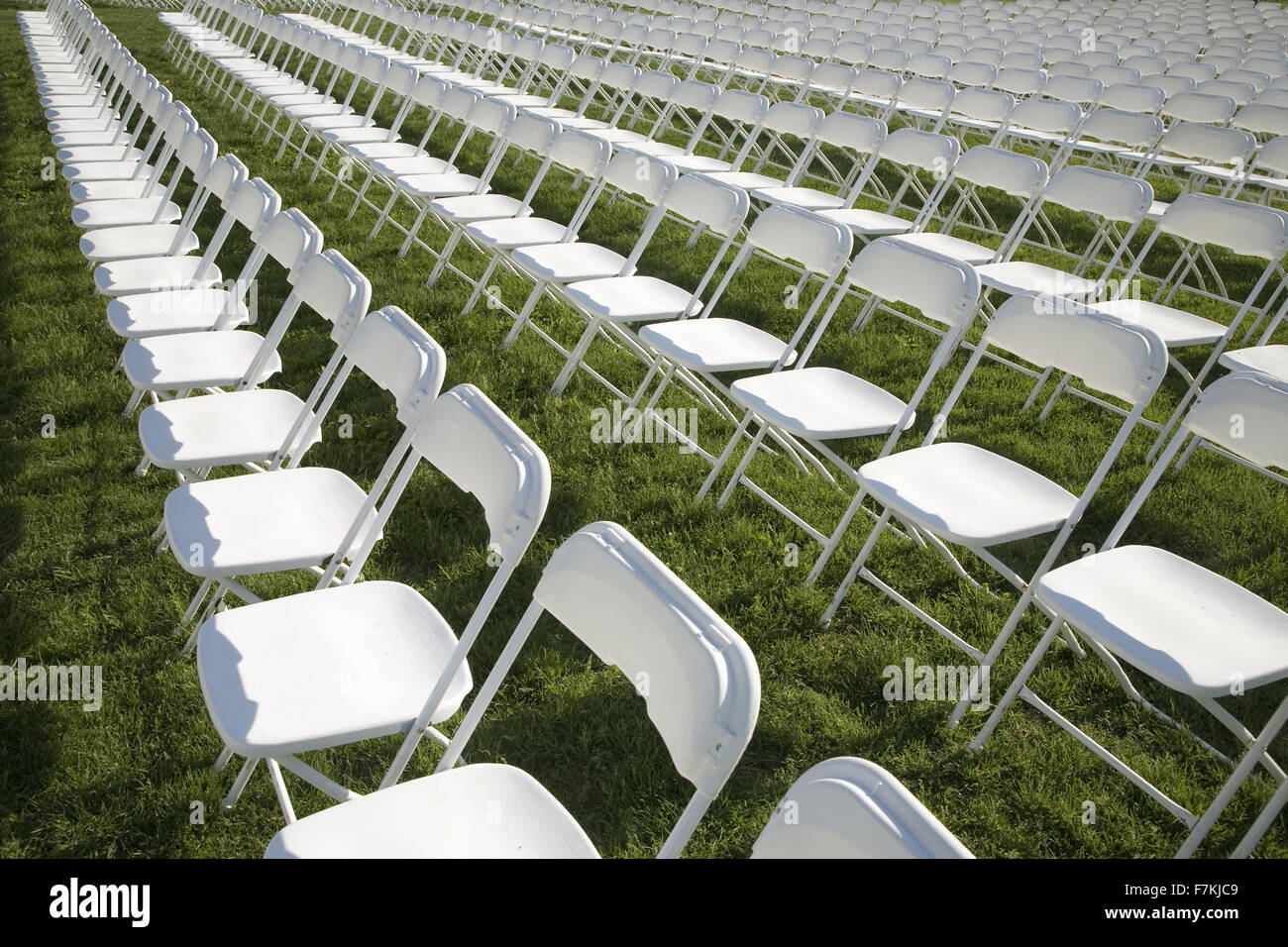 Rows of empty white chairs in grassy field in Washington, DC Stock