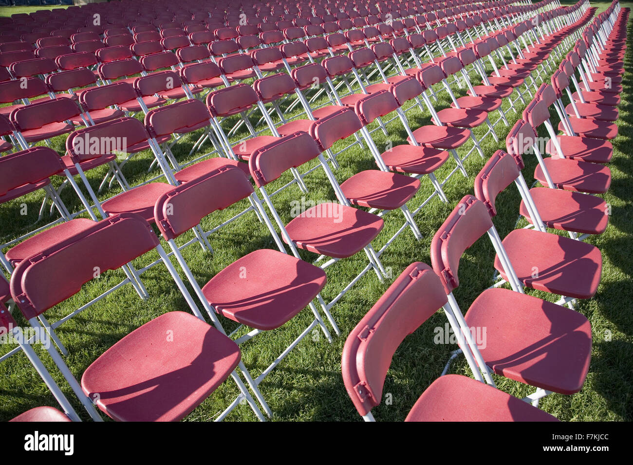 Rows of empty white chairs in grassy field in Washington, DC Stock