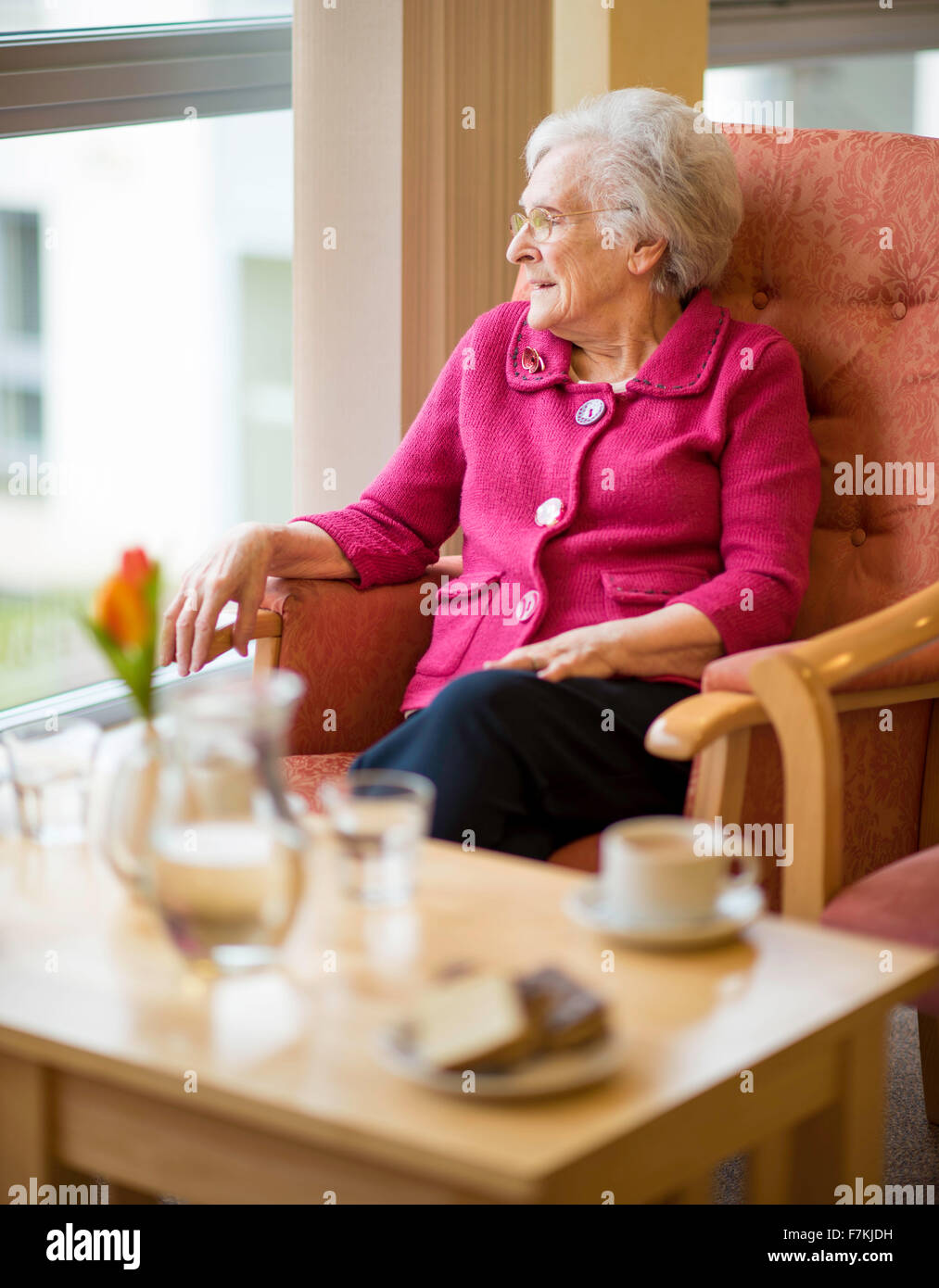 An old lady having a cup of tea in an old folks home Stock Photo