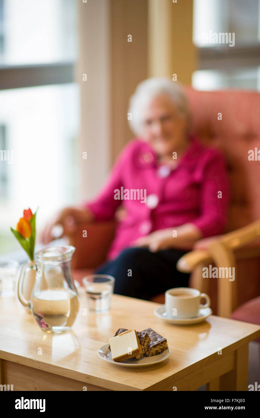 An old lady having a cup of tea in an old folks home Stock Photo