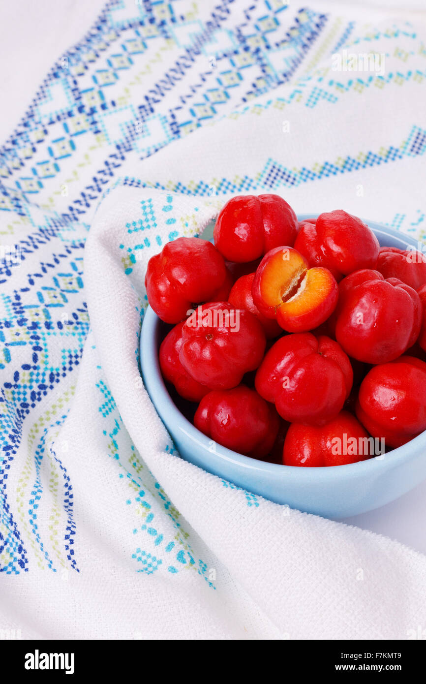 Malpighia glabra (red acerola), tropical fruit in bowl. Selective focus Stock Photo