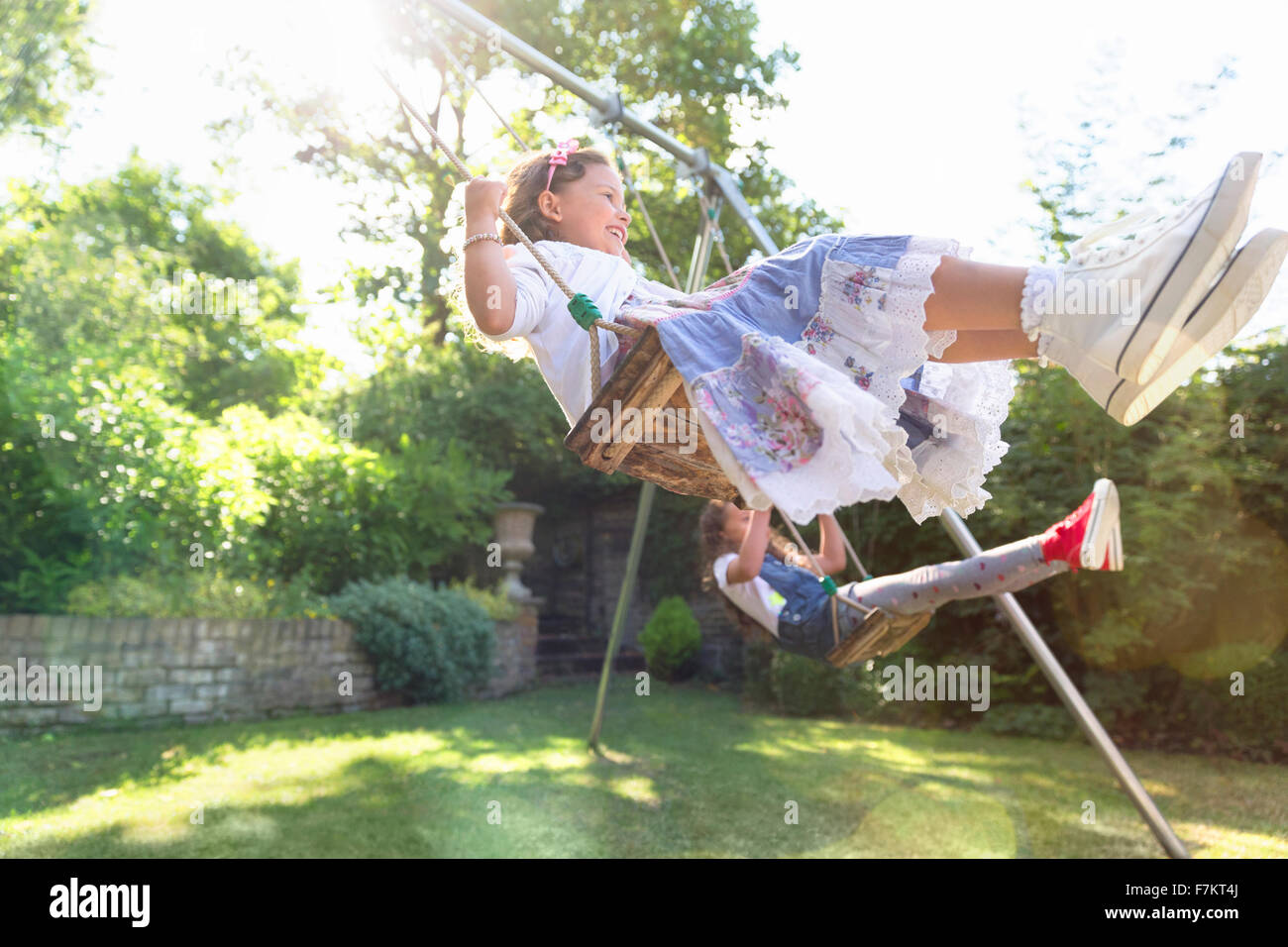 Carefree girls swinging in backyard Stock Photo