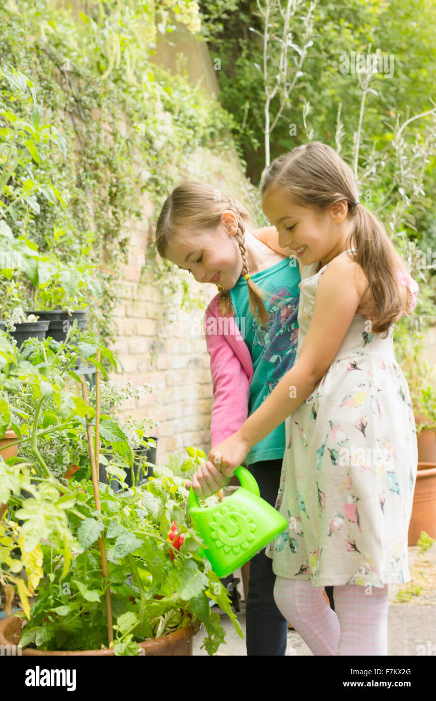 Girls watering plants in garden Stock Photo