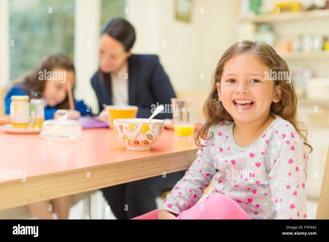 Portrait enthusiastic girl at breakfast table Stock Photo