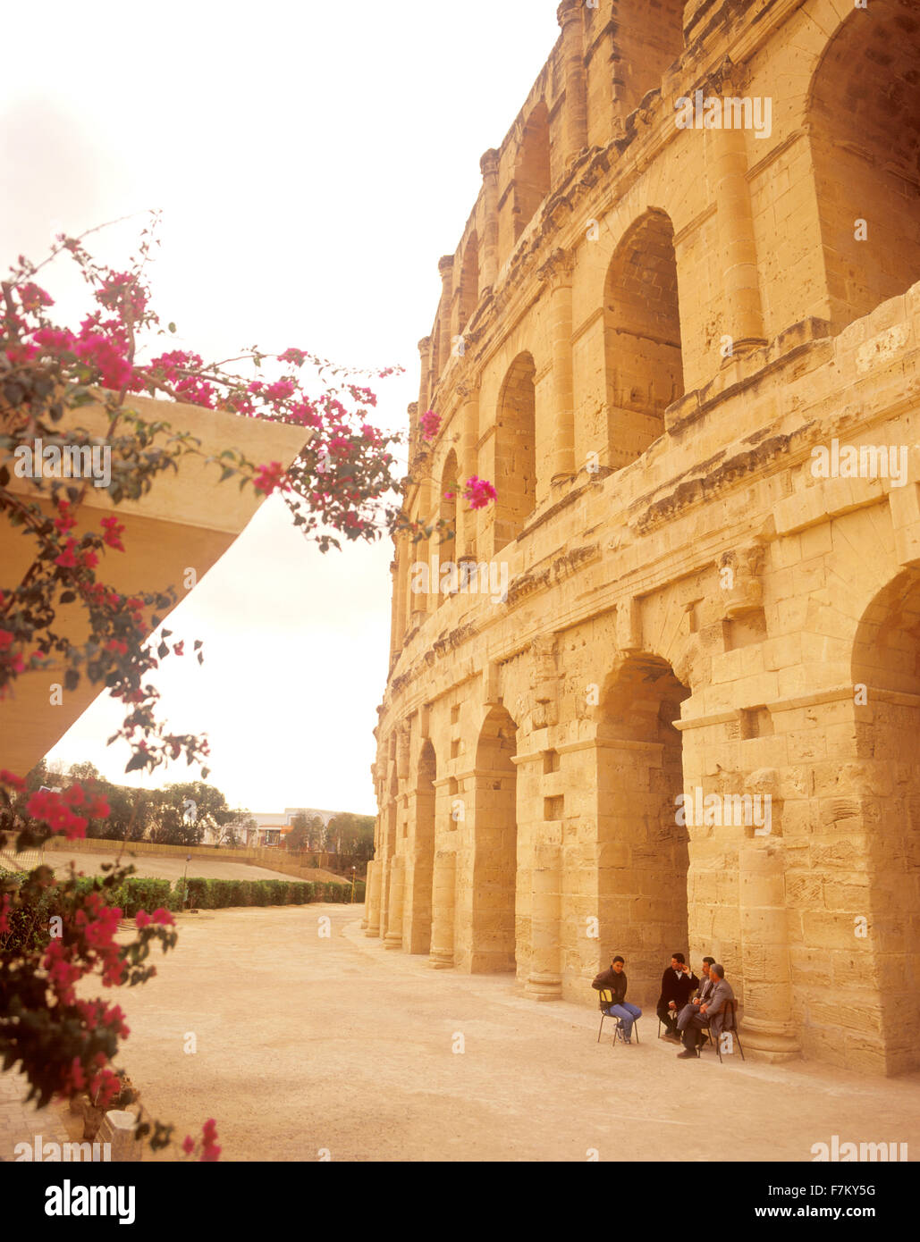 A group of Tunisian men sit outside of the Ancient Roman amphitheater of El Jem. Stock Photo