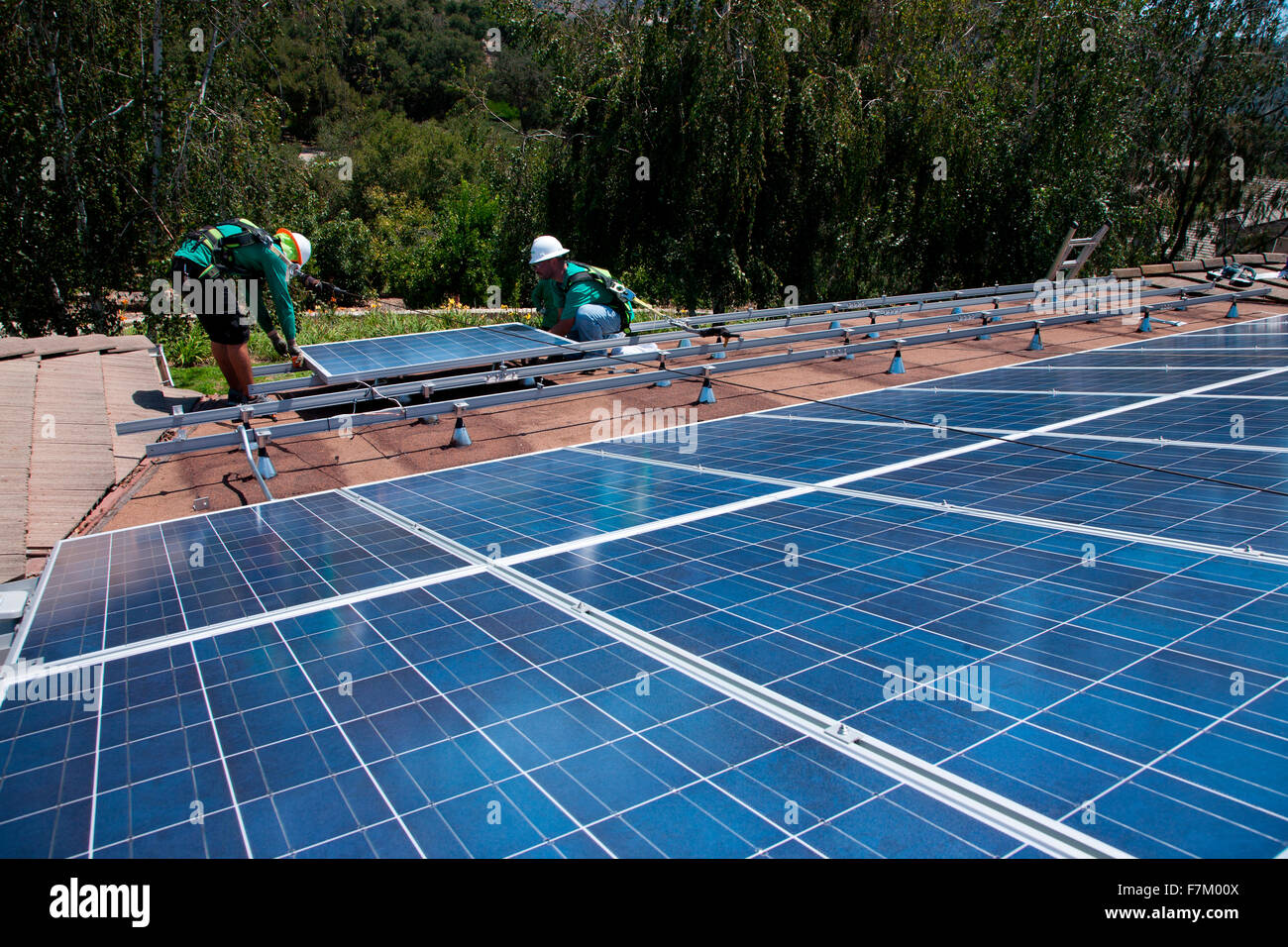 Two male solar workers install solar panels on home in Oak View, Southern California Stock Photo