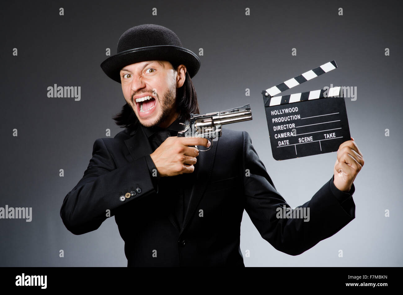 Man with gun and movie clapboard Stock Photo - Alamy