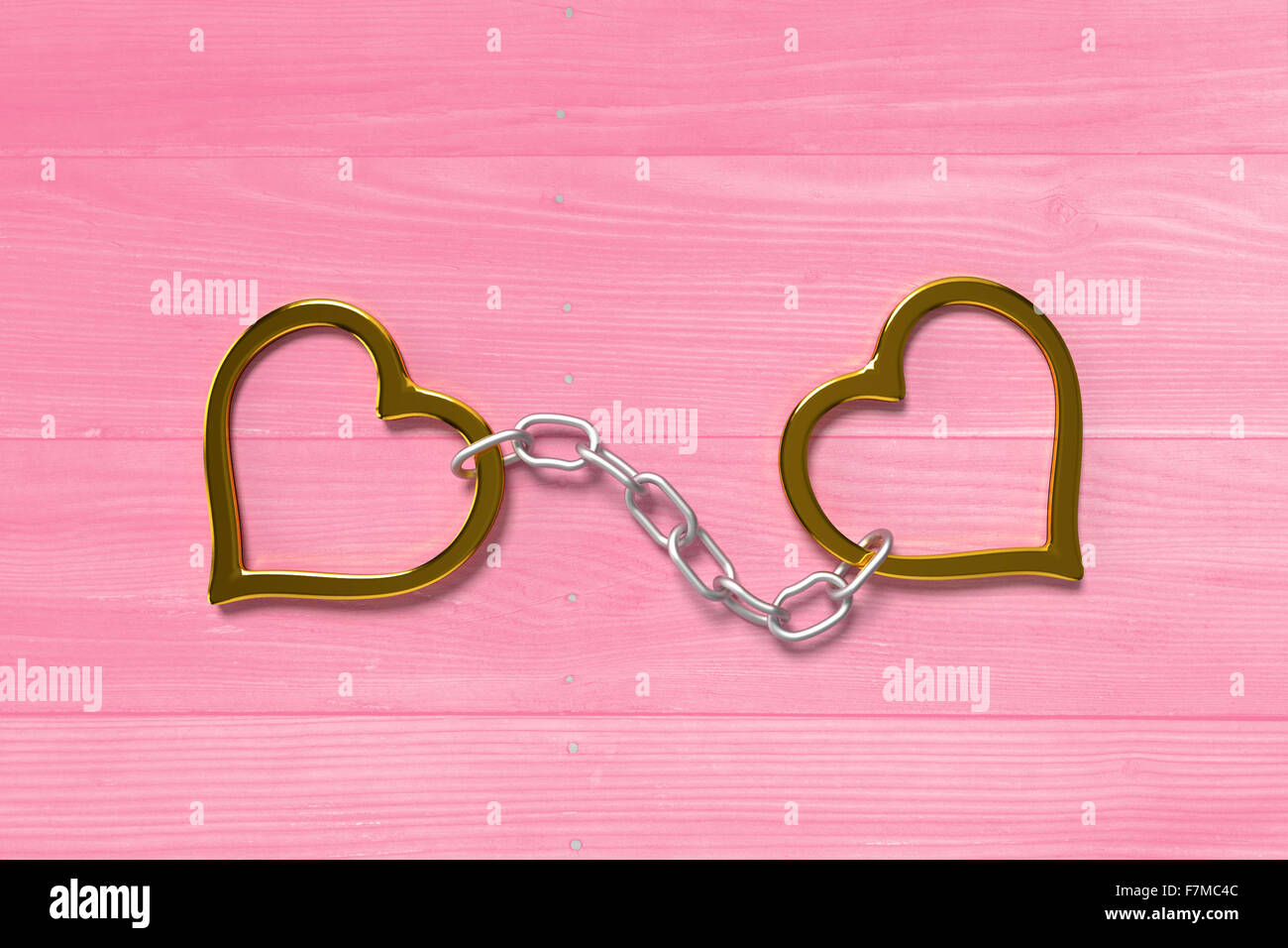 golden love handcuffs on the pink bright planks Stock Photo