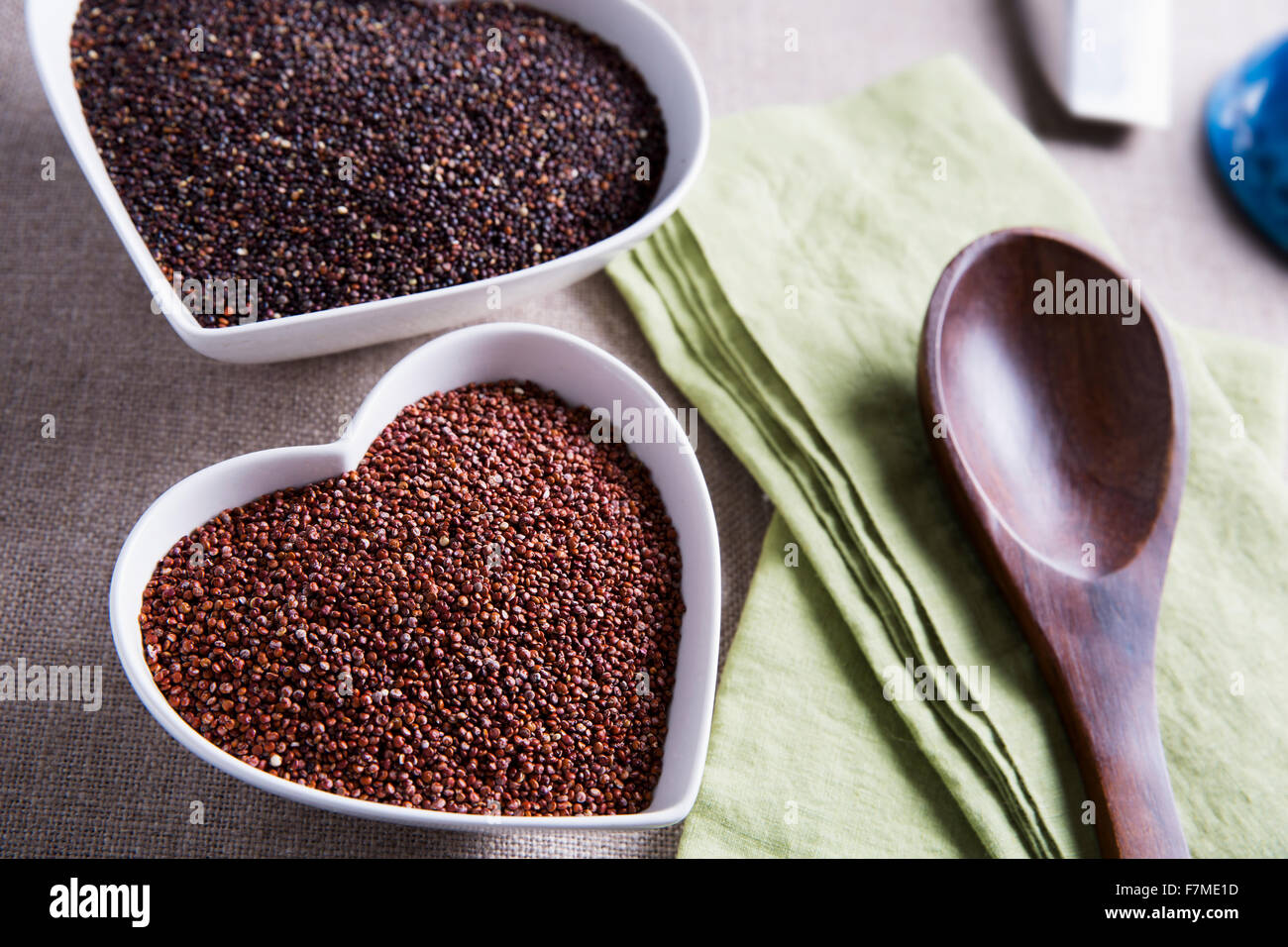 Heart shaped bowls filled with healthy red and black quinoa seeds. Stock Photo