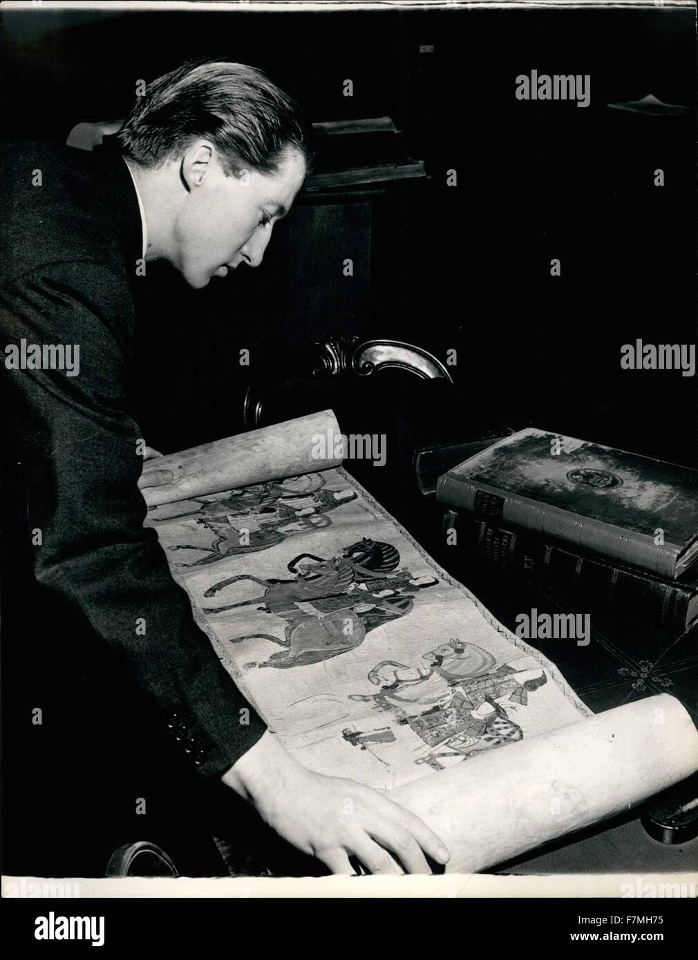 1953 - College of Arms: Mr. Robin Mirrlees, Rouge Dragon Pursuivant examining a famous roll of arms almost unique of its kind. It is the Westminster Tournament Roll prepared for a tournament Henry VIII held in honour of his first wife, Catherine of Aragon. The portion visible shows the Heralds and Pursuivants of the day riding to officials at the event. They are seen wearing their tabards and holding their batons of offne. © Keystone Pictures USA/ZUMAPRESS.com/Alamy Live News Stock Photo
