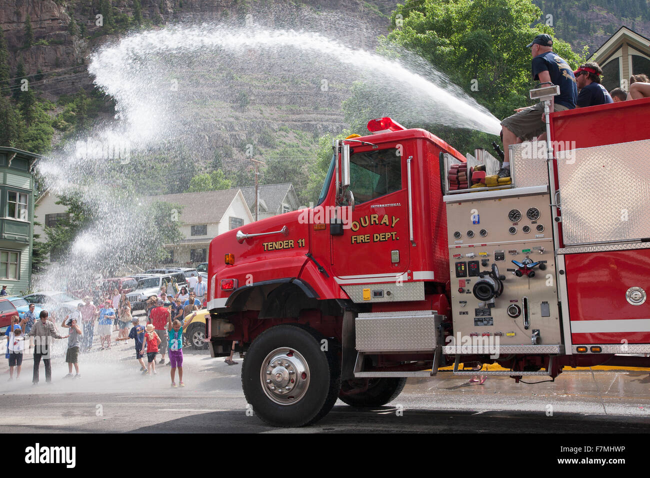 Ouray Firetruck squirts off kids in July 4 Independence Day Parade, Ouray, Colorado Stock Photo
