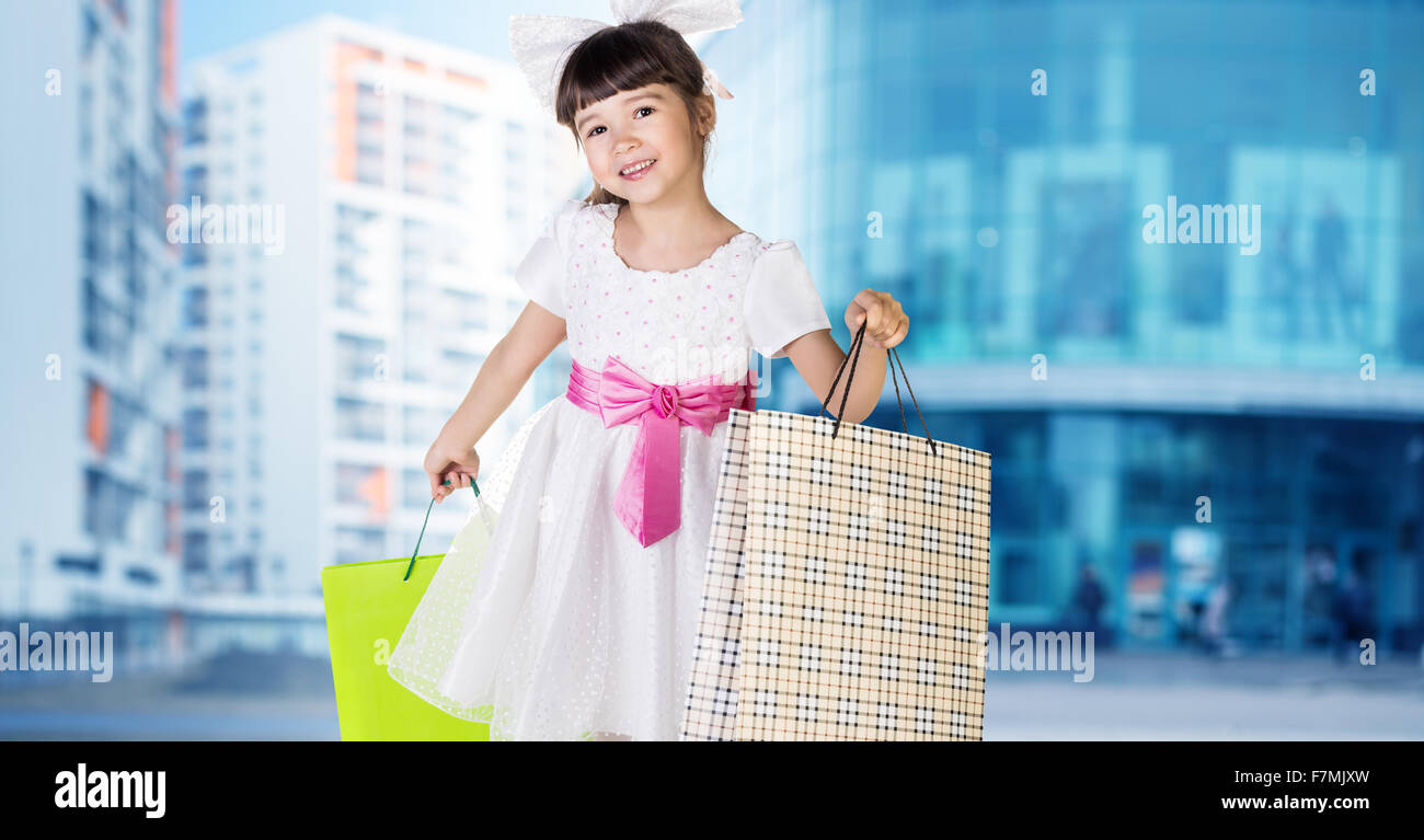 Cute little girl in big wear with packages Stock Photo