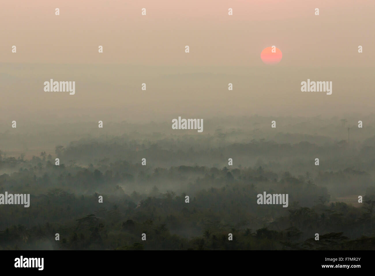 Colorful sunrise over Merapi volcano and Borobudur temple in misty ...