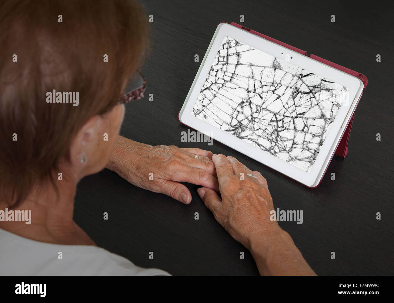 Senior lady with tablet, cracked screen, concept of insurance Stock Photo
