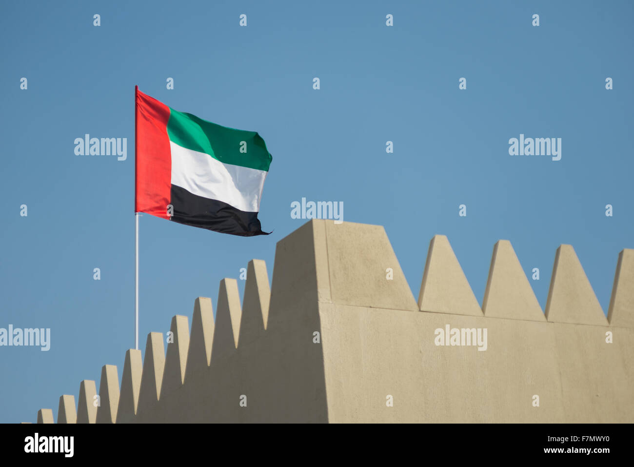 Flag of the United Arab Emirates flying from a pole Stock Photo