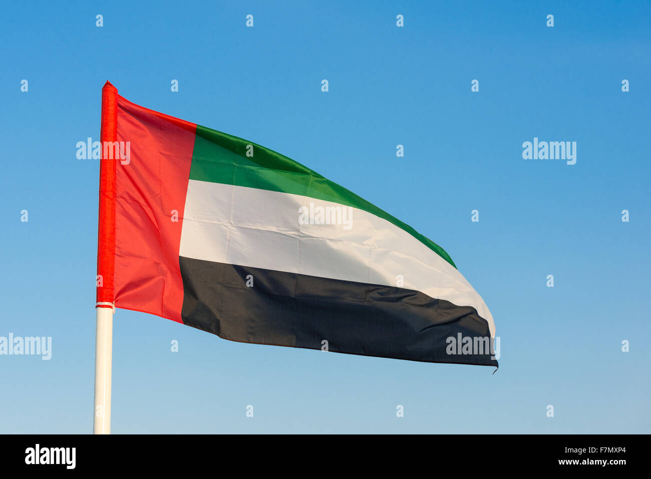 Flag of the United Arab Emirates flying from a pole Stock Photo
