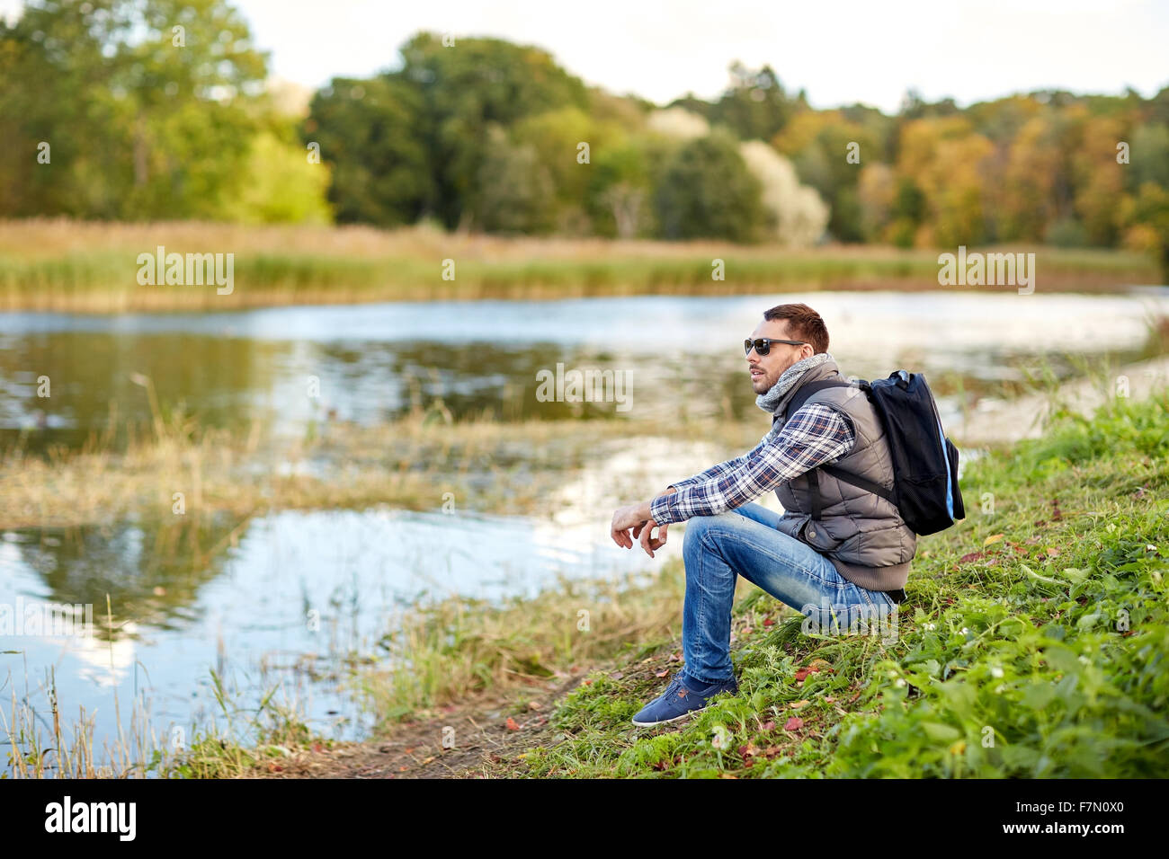 Man sitting lake bank backpack hi-res stock photography and images - Alamy