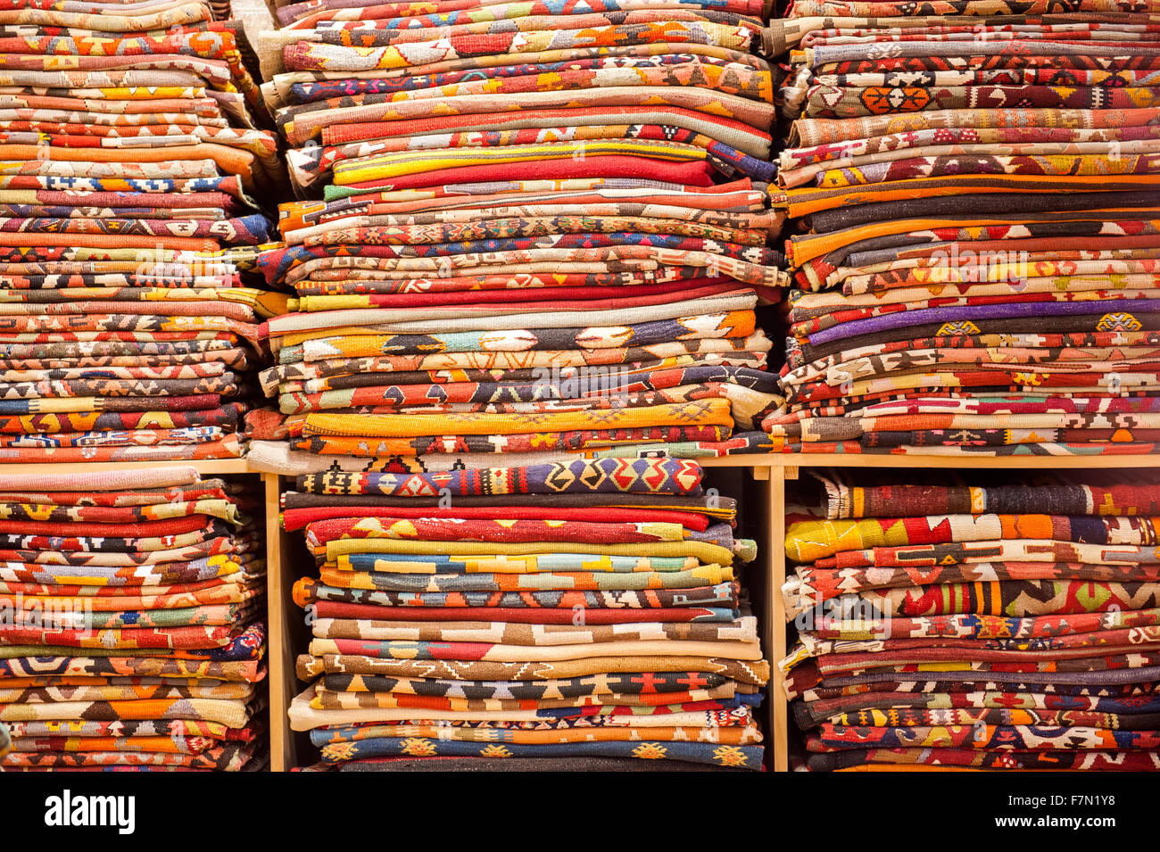 A large selection of blankets and their patterns on a shelf Stock Photo