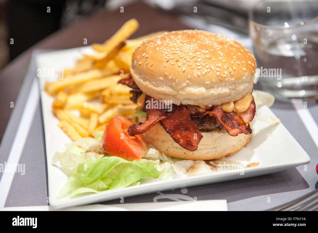 Close up of a bacon cheese burger and fries on a plate Stock Photo