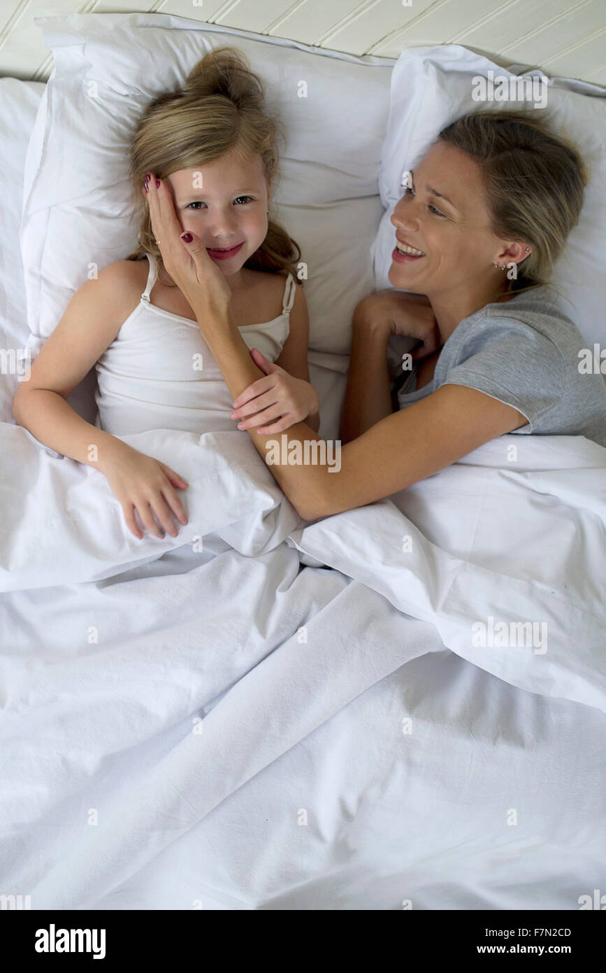 Mother and daugther lying in bed together Stock Photo