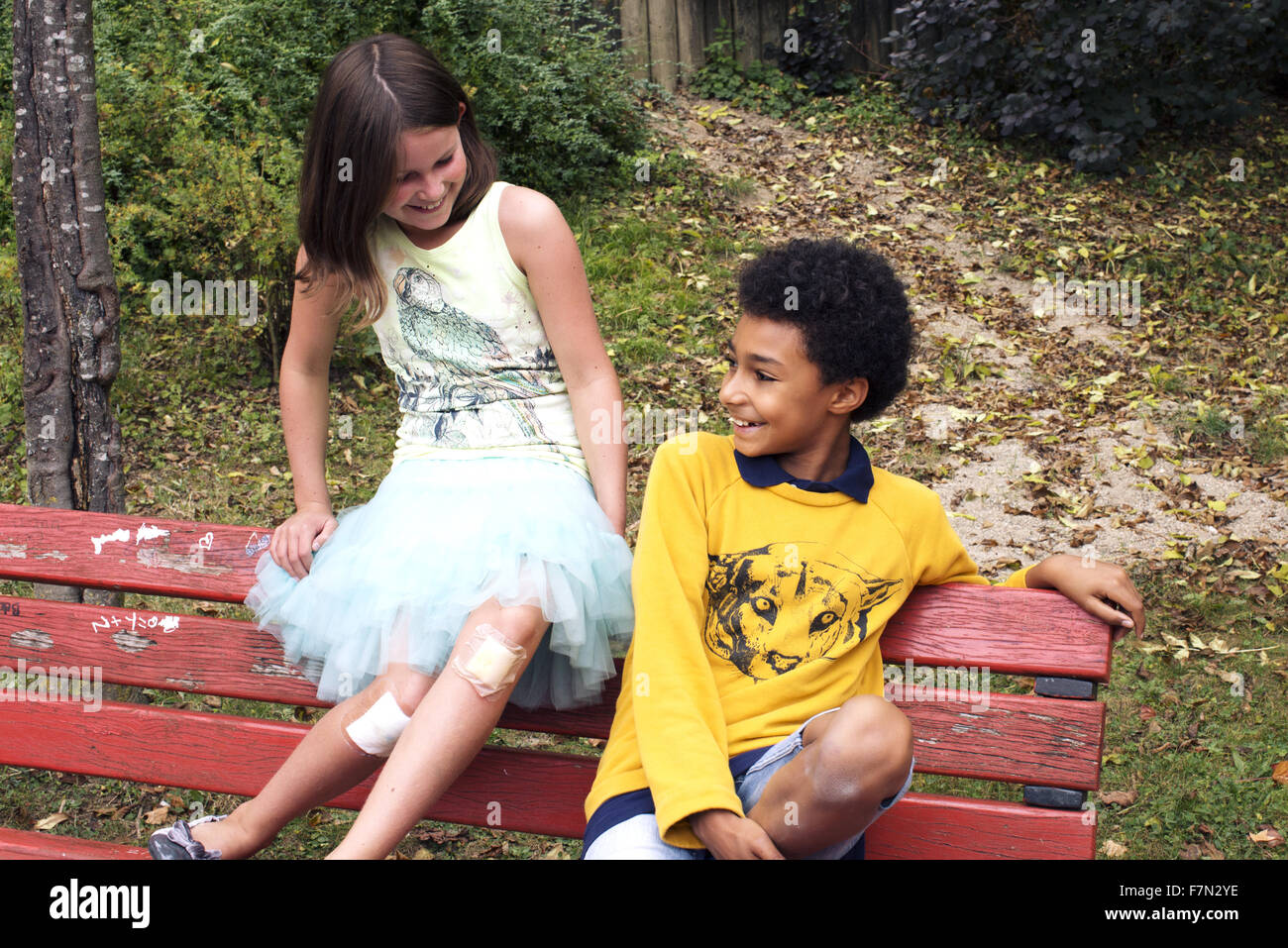 Young friends hanging out together on park bench Stock Photo