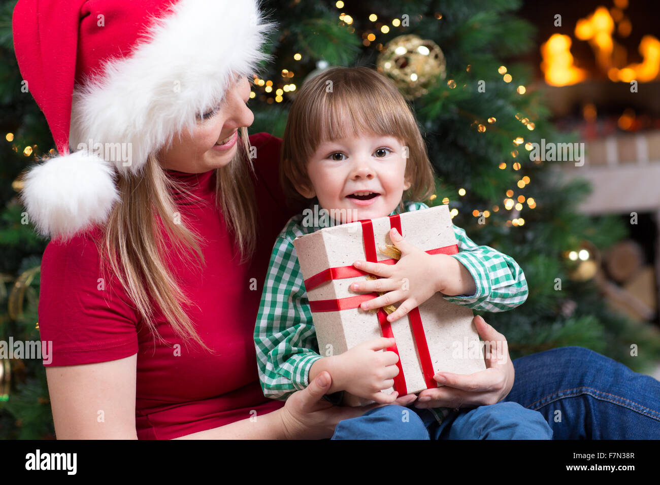 Mother weared Santa and child boy with christmas present Stock Photo