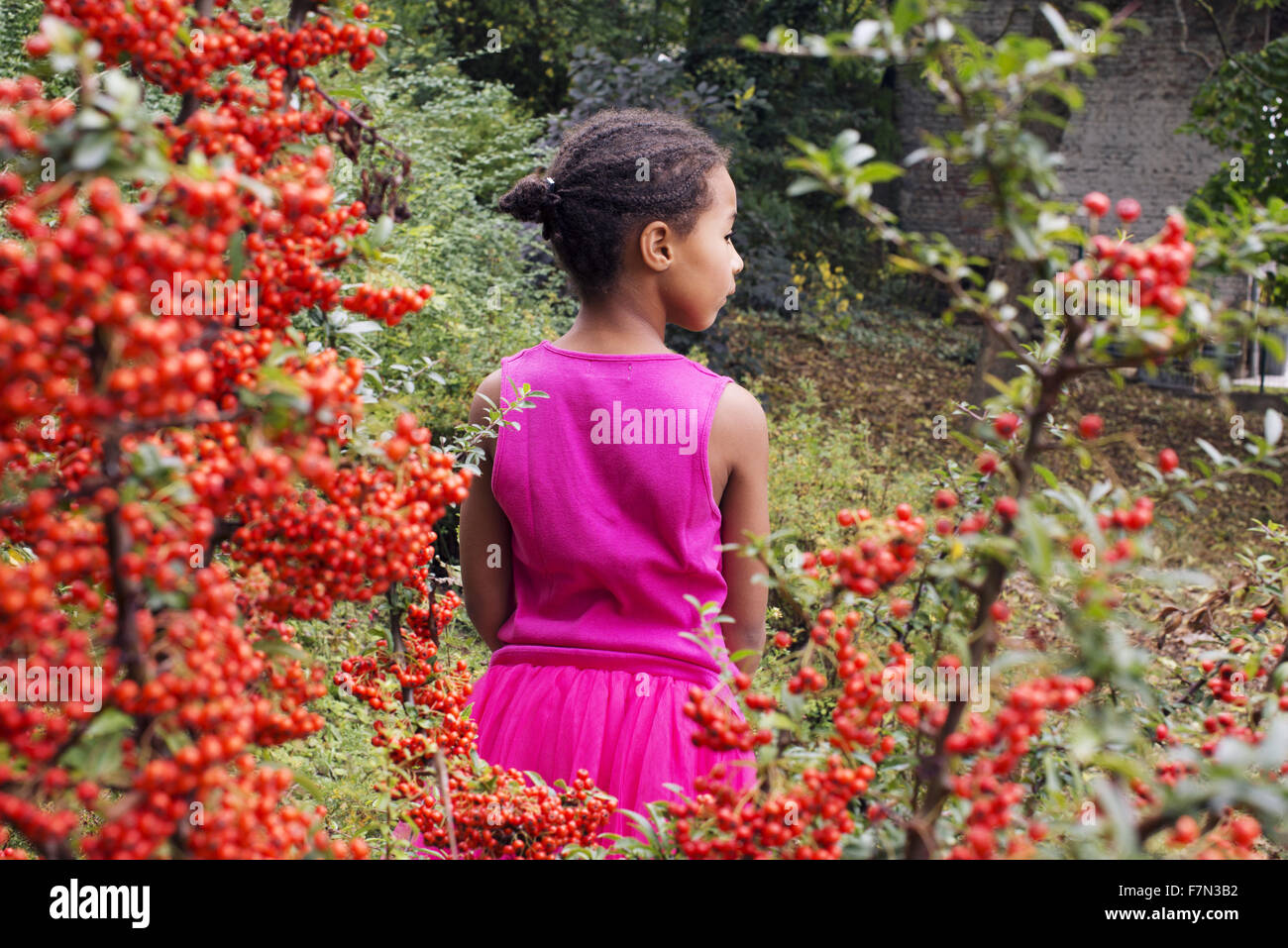 Girl standing alone outdoors, rear view Stock Photo