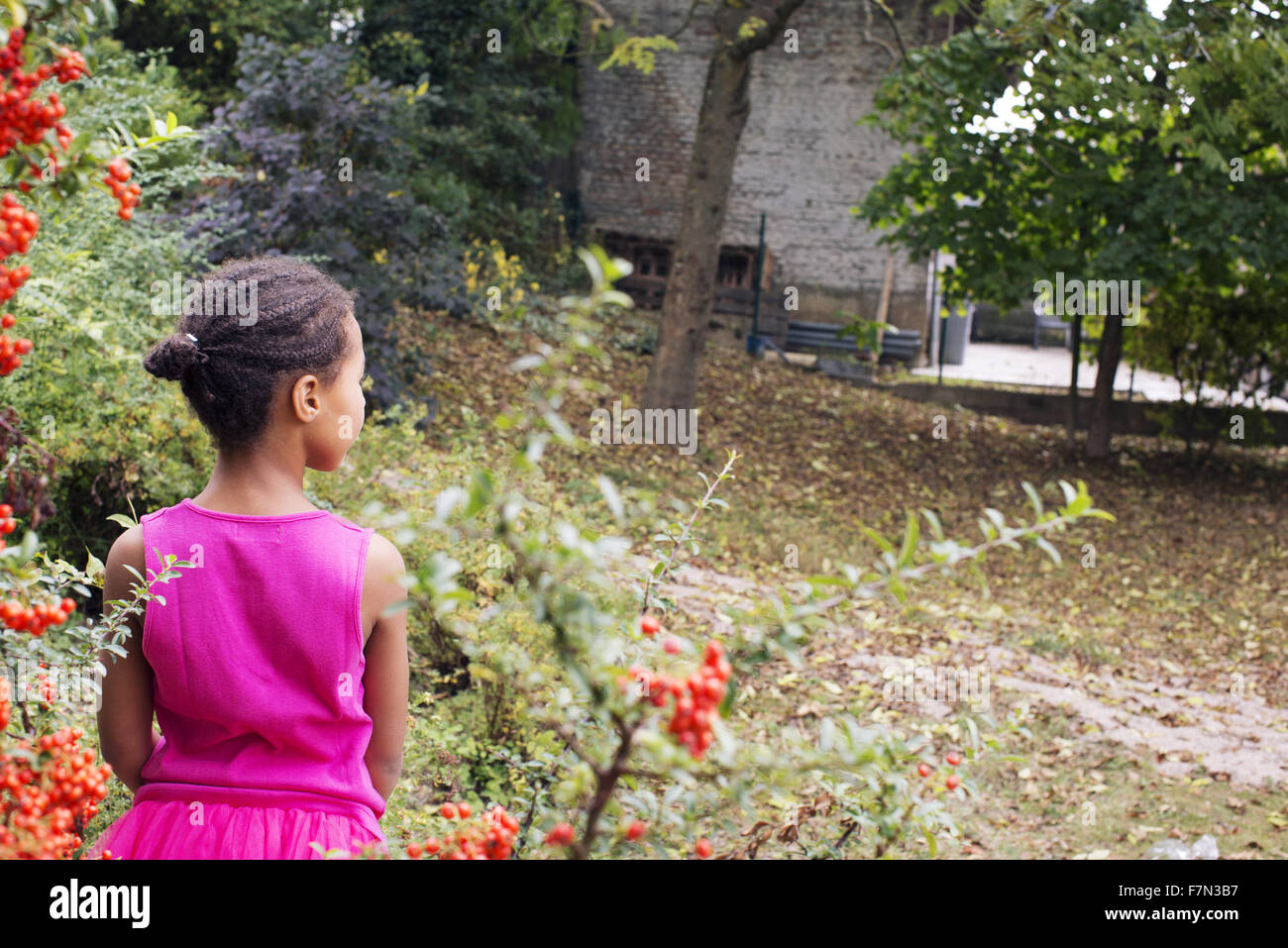 Girl standing alone outdoors, rear view Stock Photo
