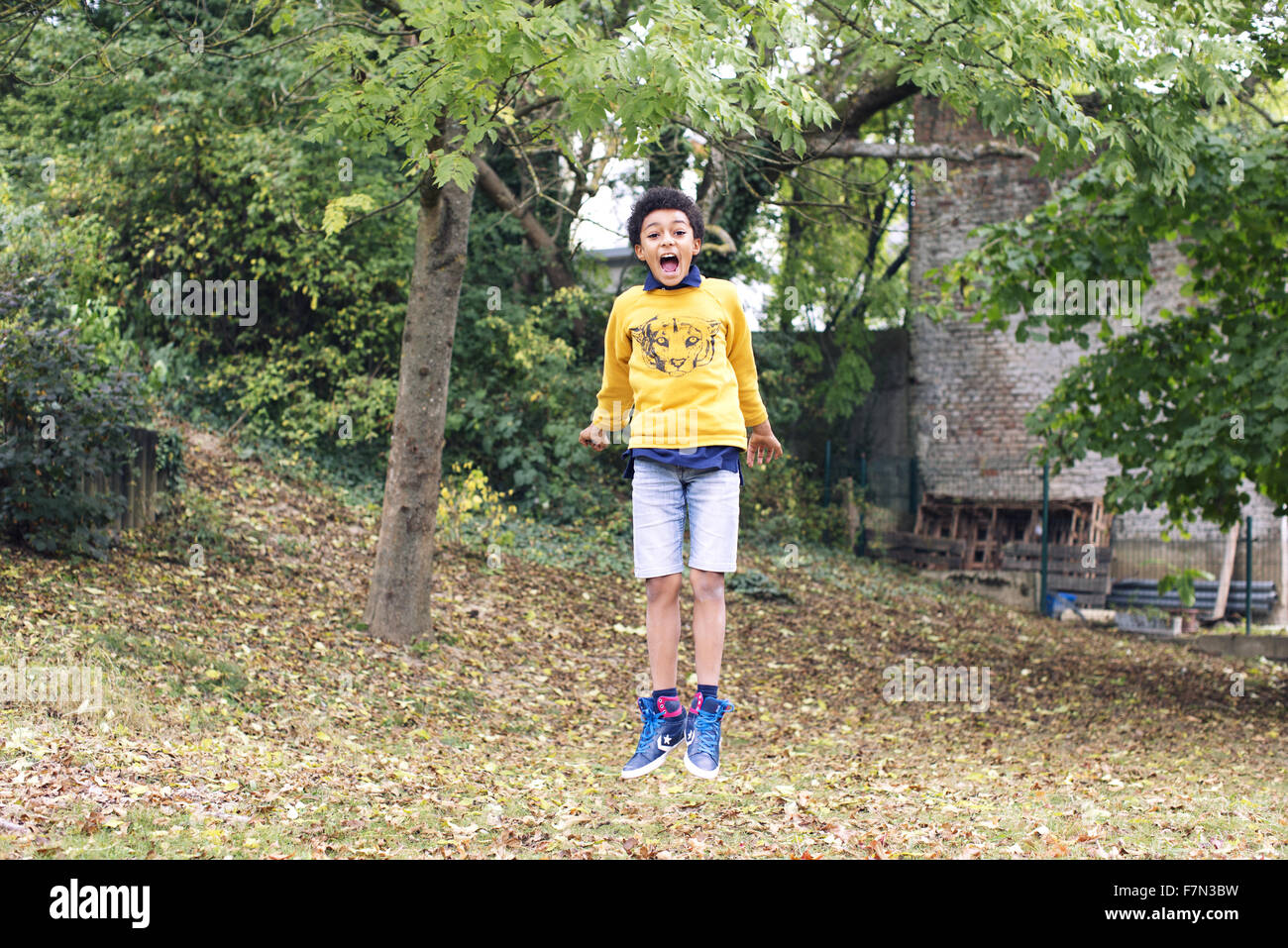 Boy jumping in midair outdoors Stock Photo