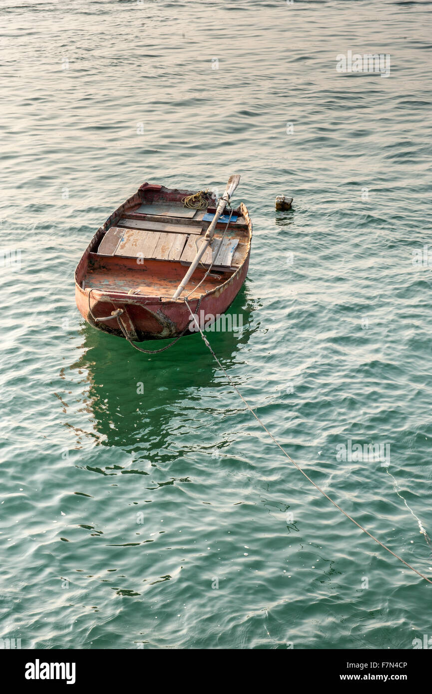 Single floating boat on water with ropes and equipment on board Stock Photo