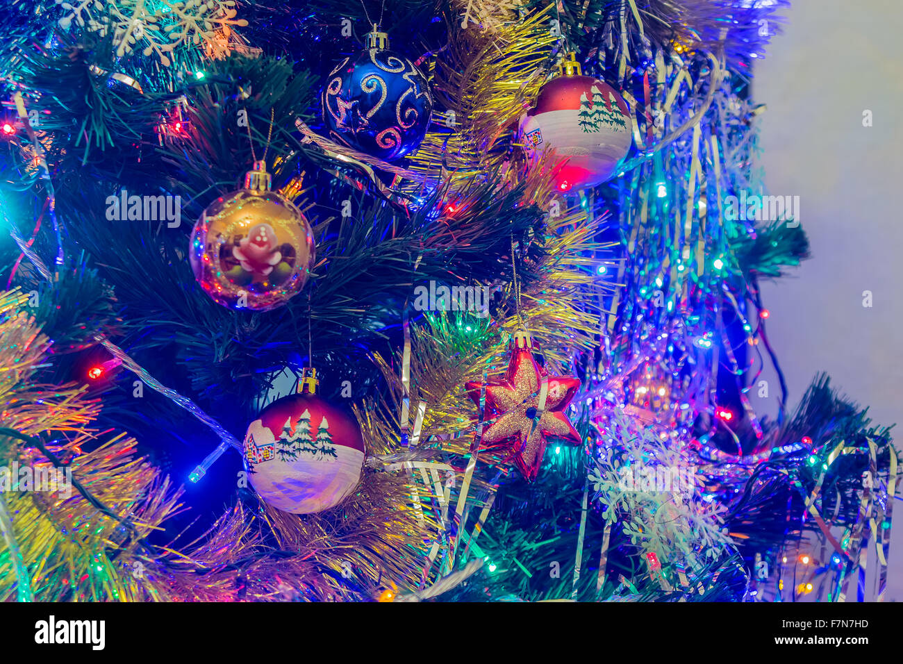 Christmas New Year's toys on a blurred background of Christmas trees and garlands. Stock Photo