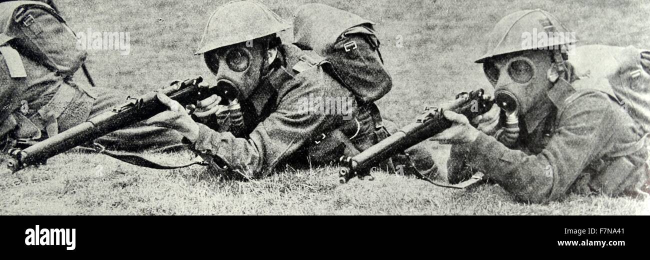 Photograph of Soldiers wearing gas masks whilst aiming their guns. Dated 1939 Stock Photo