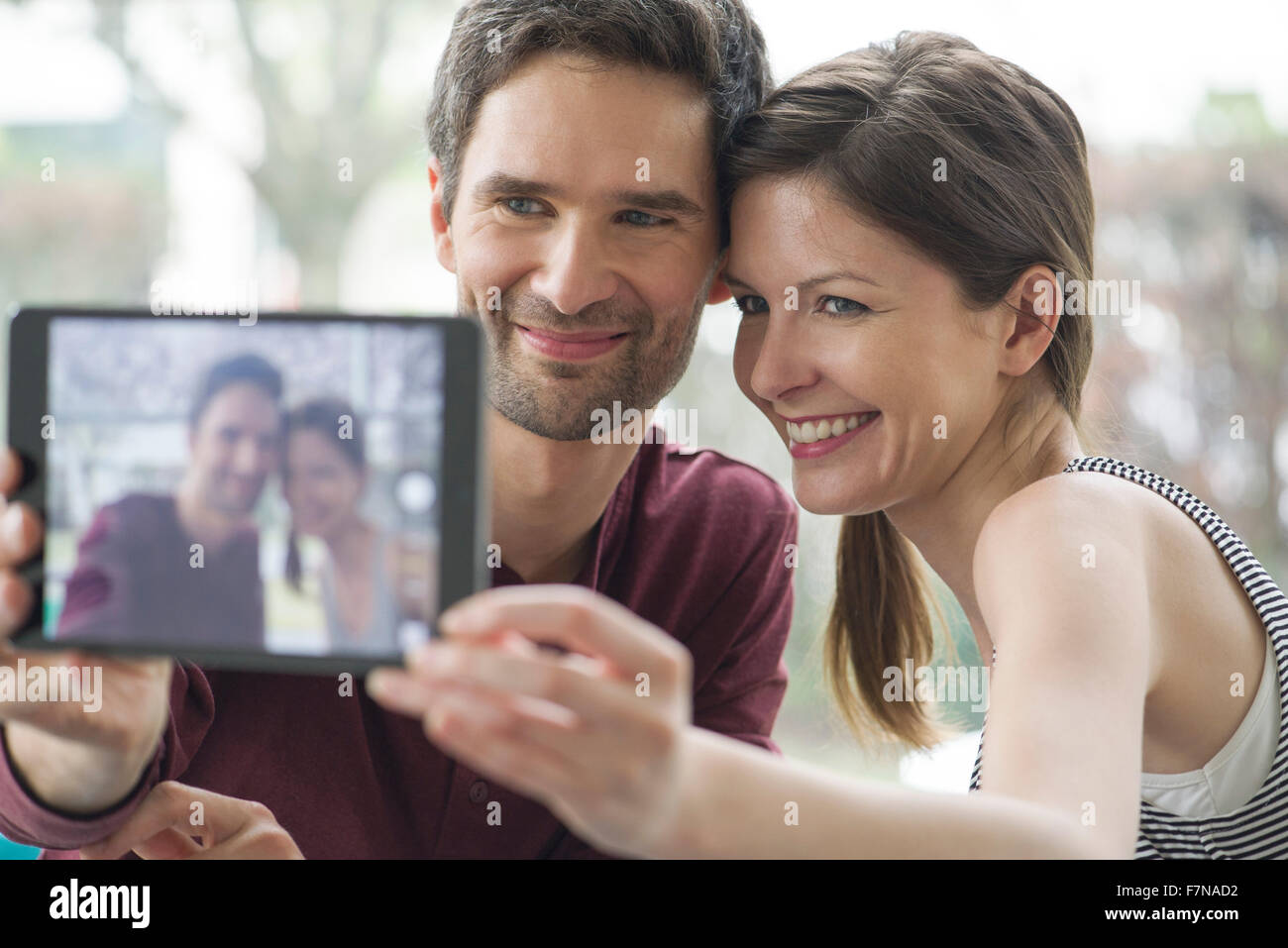Couple using digital tablet to take a selfie Stock Photo