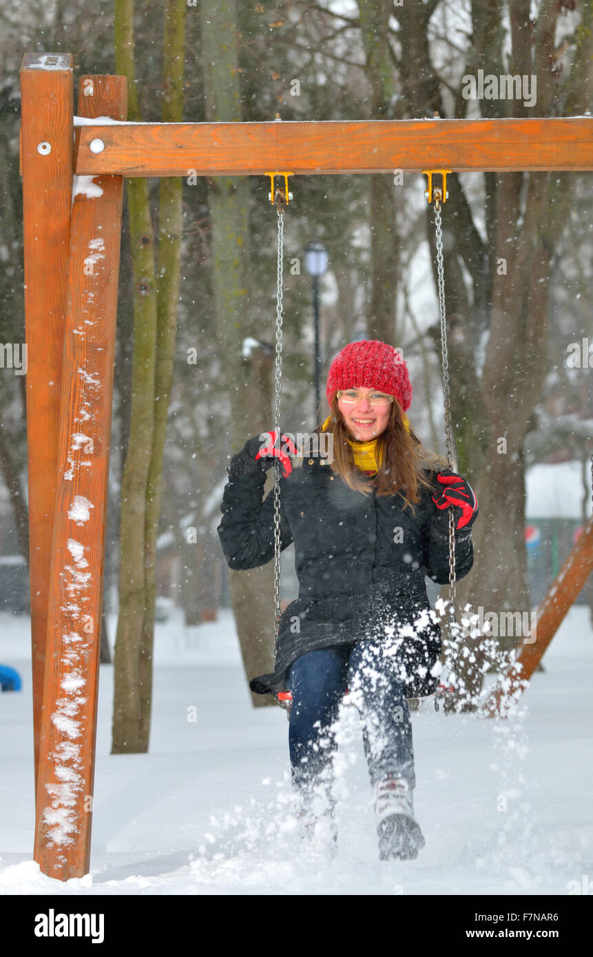 teen girl swing on snowy winter day Stock Photo
