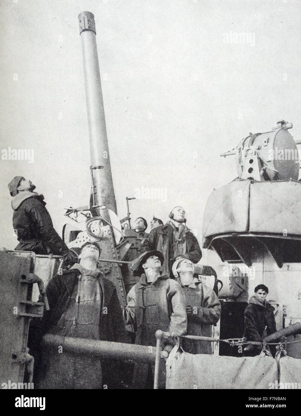 Photograph of the crew members of the British destroyer looking up toward an overhead aircraft. Dated 1940 Stock Photo