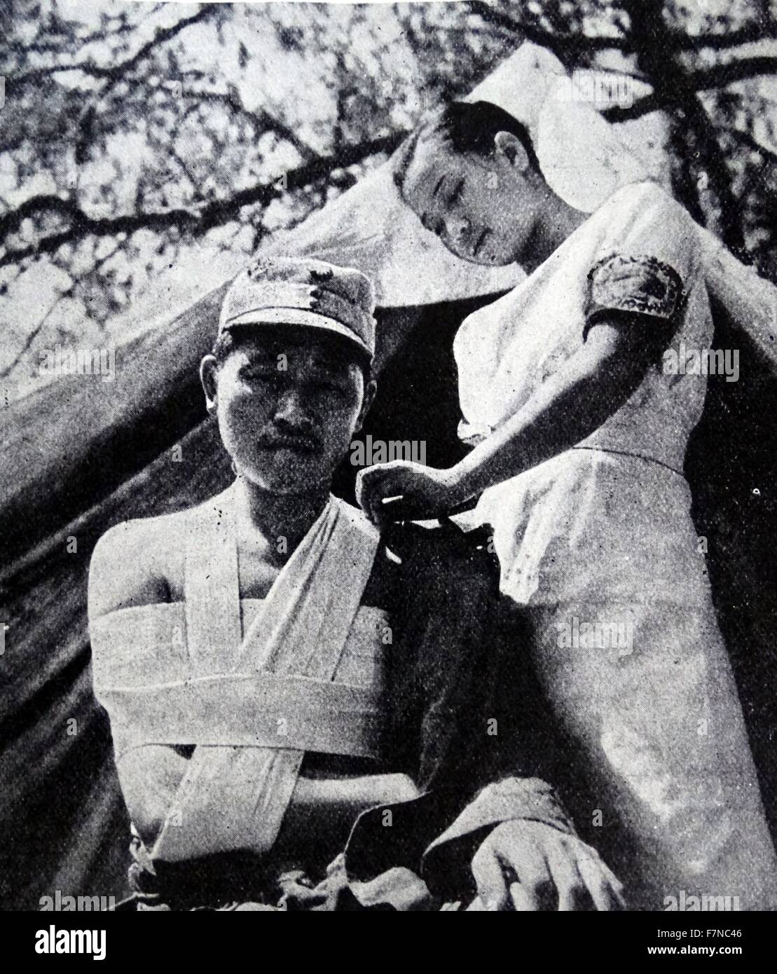 A Chinese nurse of the American Baptist Surgical Unit, tends a wounded chinese soldier, during World War Two Stock Photo