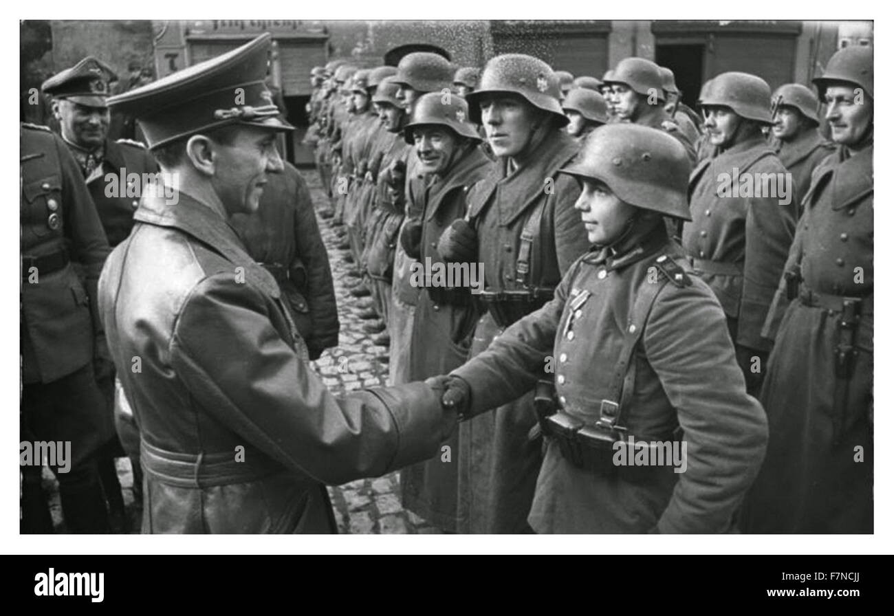 Nazi German Propaganda minister Josef Goebbels, congratulates a young soldier, after receiving the Iron Cross during the last weeks of World war two; 1945 Stock Photo