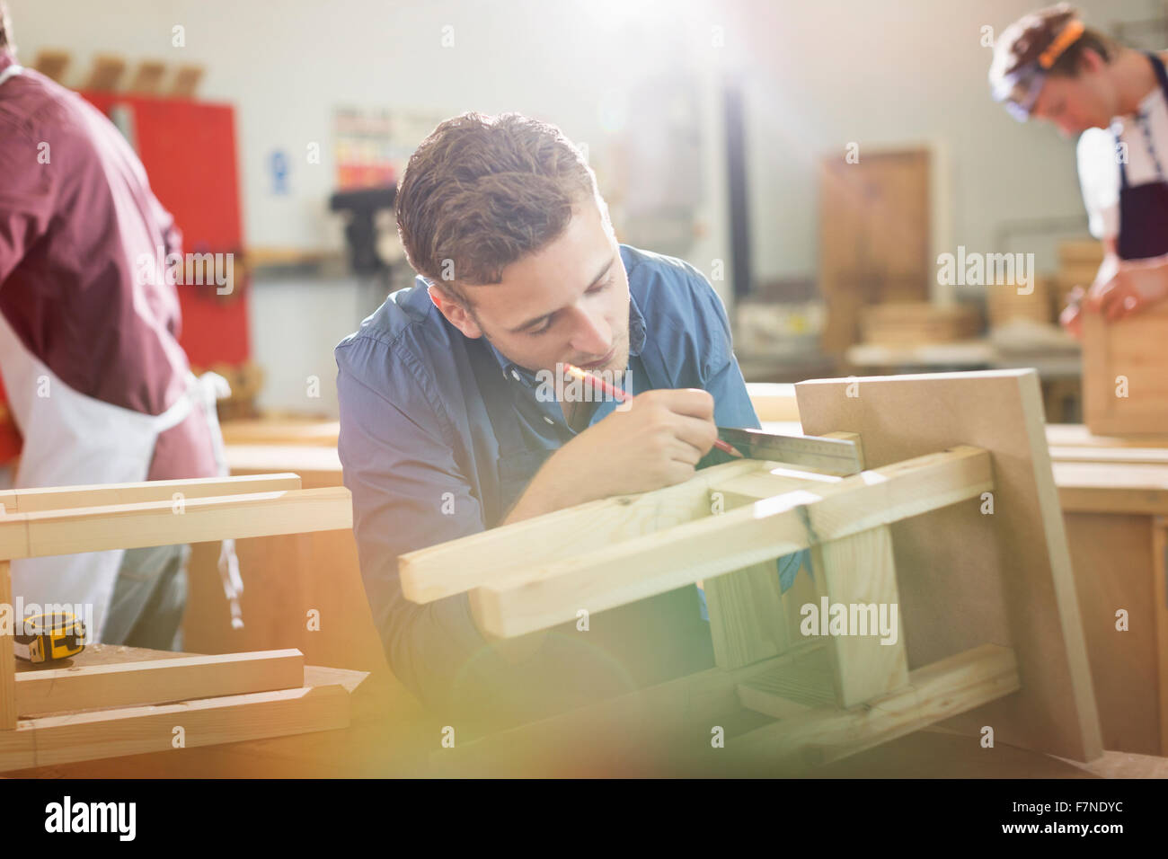 Carpenter measuring and marking wood in workshop Stock Photo - Alamy