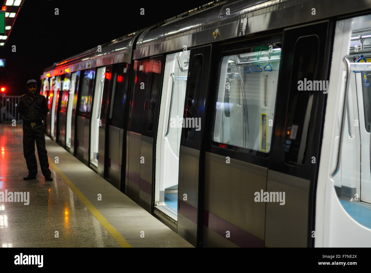 A Security Guard Stands Near The Open Door Of An Empty Metro Train