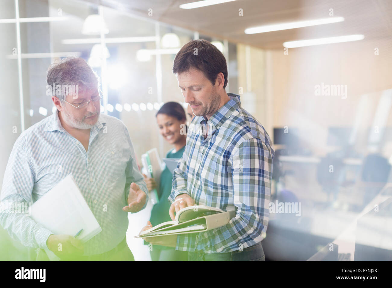 Men discussing book in adult education classroom Stock Photo