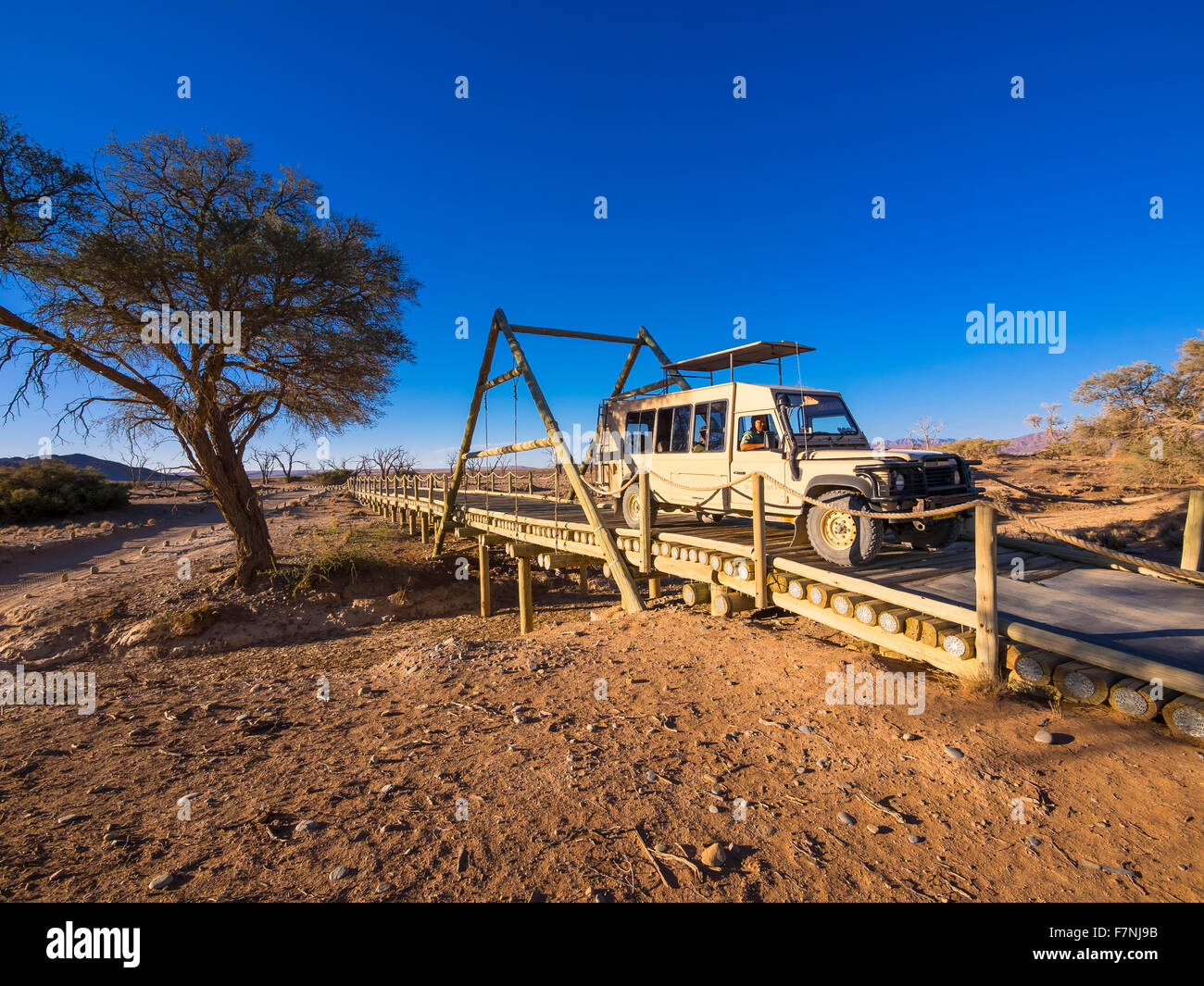 Namibia, Hardap, off-road vehicle crossing wooden bridge at Kulala Wilderness Reserve Stock Photo