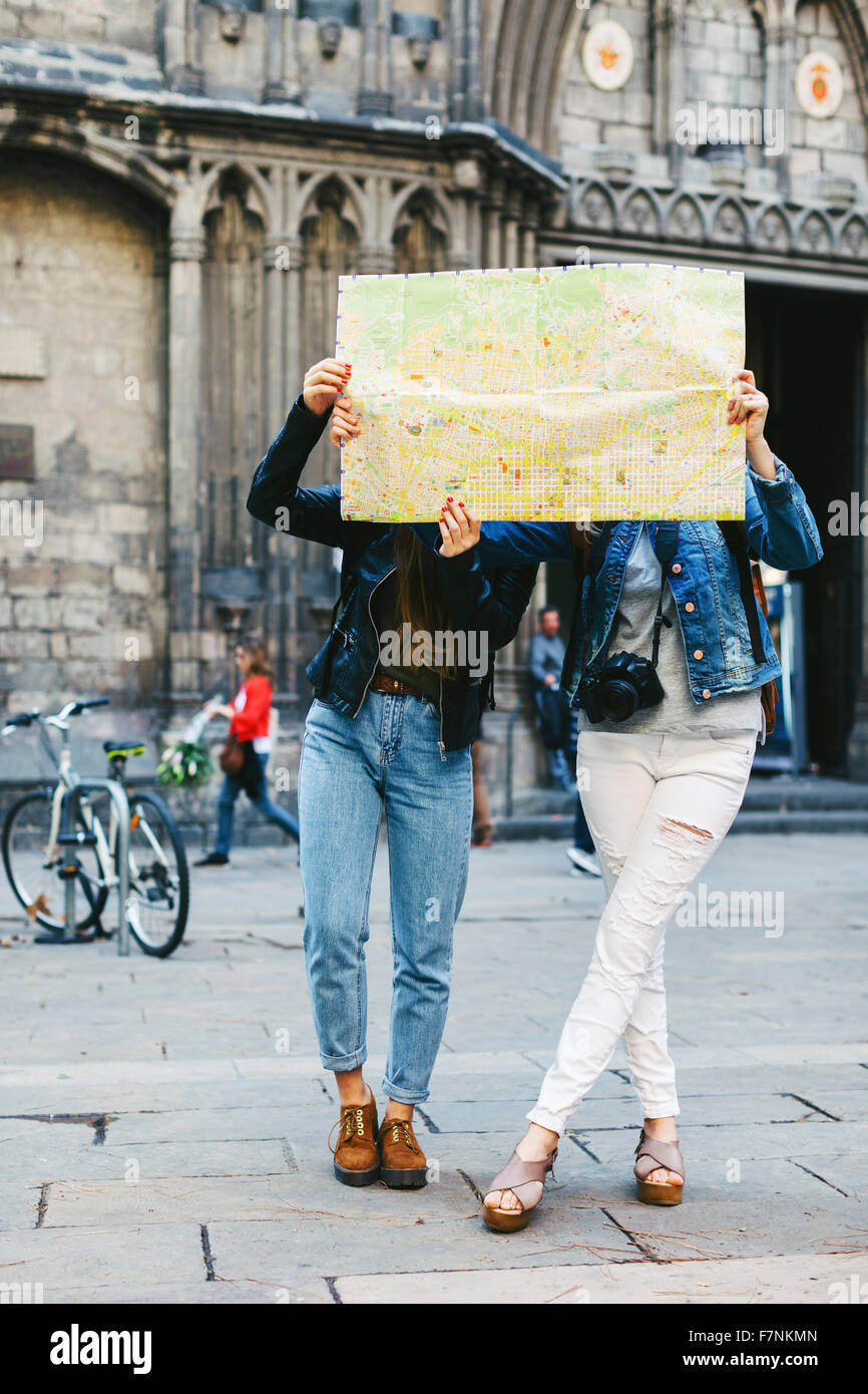 Spain, Barcelona, two young women reading map Stock Photo